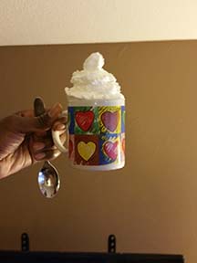 A Cup. That has Ice Cream. That is also whip cream on it.